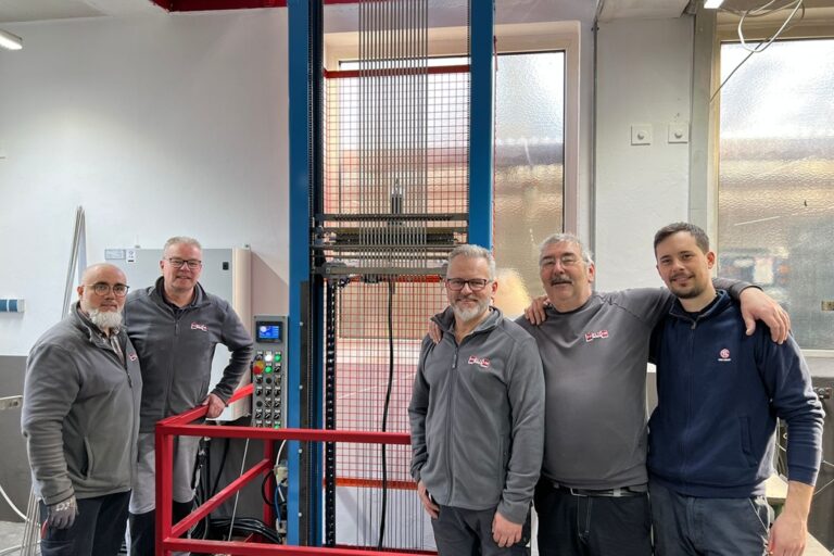 HELIOS Heizelemente Mitarbeitende vor der neuen Füllmaschine für Rohrheizkörper